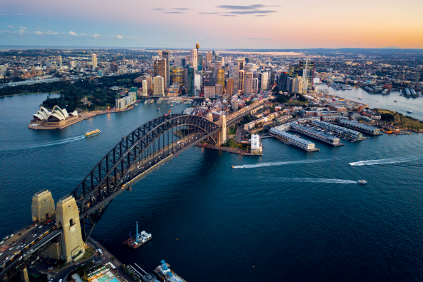An aerial shot of the Sydney Harbour Bridge and surrounding metropolitan. 